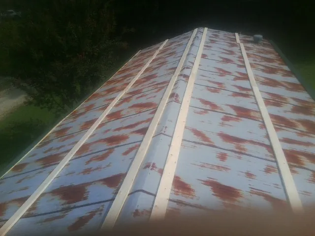 Rusted metal roof panels with new wood purlins before replacement — Storm Damage Roof Repair in Nortonville by Roofing Brothers