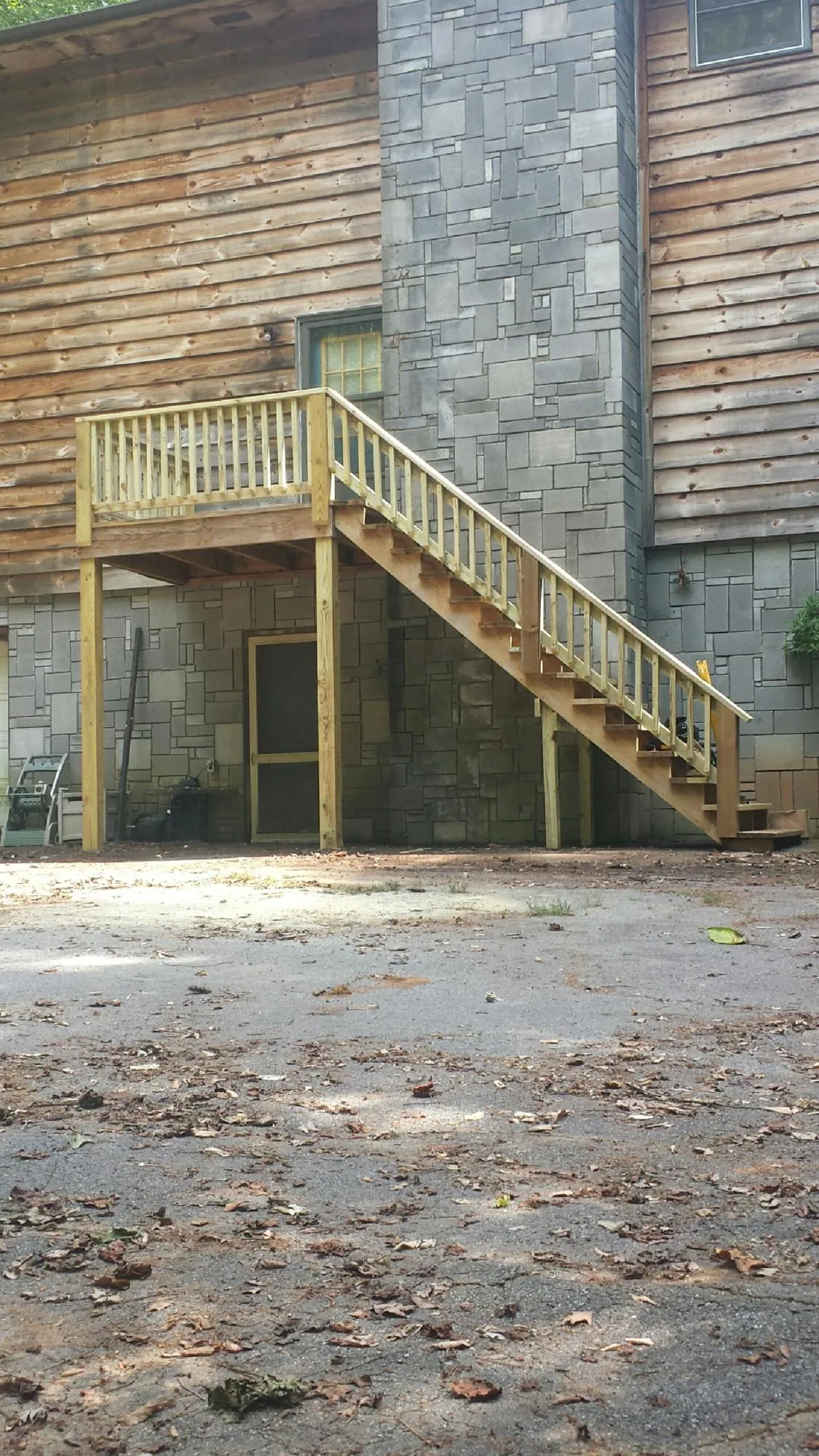 New pressure treated deck and stair landing on a log home in Nortonville