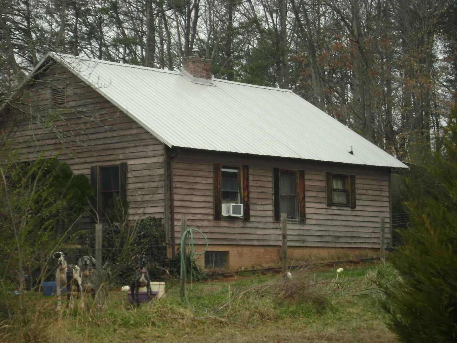 White metal roof on an old wood sided farmhouse, from a Metal Roof Installation job in Nortonville